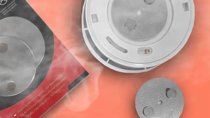mounting kit smoke detector and magnet on orange background with smoke