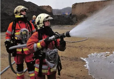 photo de pompier ayant en main une pompe fesant sortir de l'eau